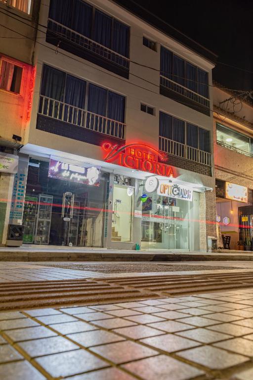 an empty street in front of a building at night at Hotel Victoria in Chinchiná