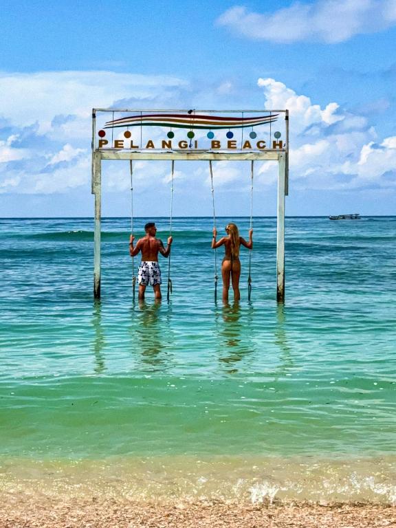 two children on swings in the water on the beach at Pelangi Cottages Gili Air in Gili Islands