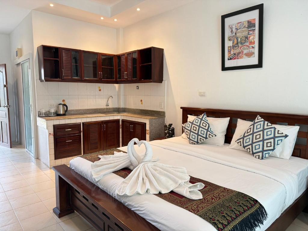 a bedroom with a large bed and a kitchen at Serene Resort Pattaya in Nong Prue