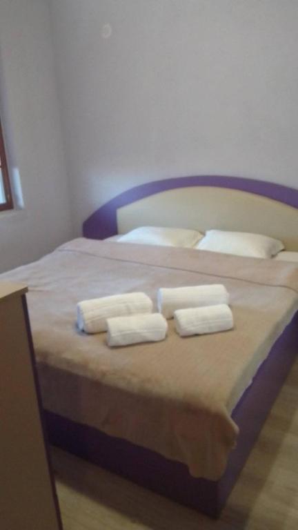 a bedroom with a bed with two towels on it at Удобство in Petrich