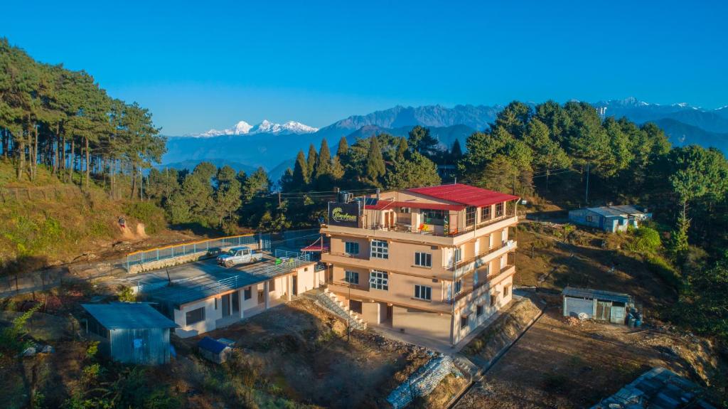 a building with a red roof on top of a hill at Hotel Himalayan Vista in Pāti Bhanjyāng
