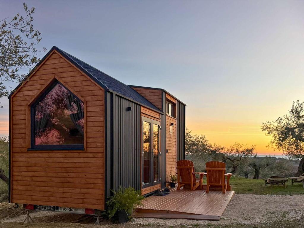 a tiny house with a deck and two chairs at Intermezzo X by Tiny Away in Citta' Sant'Angelo