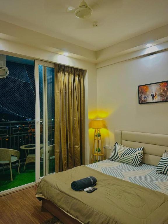 a bedroom with a bed and a window with a view at Paradise Stays in Greater Noida