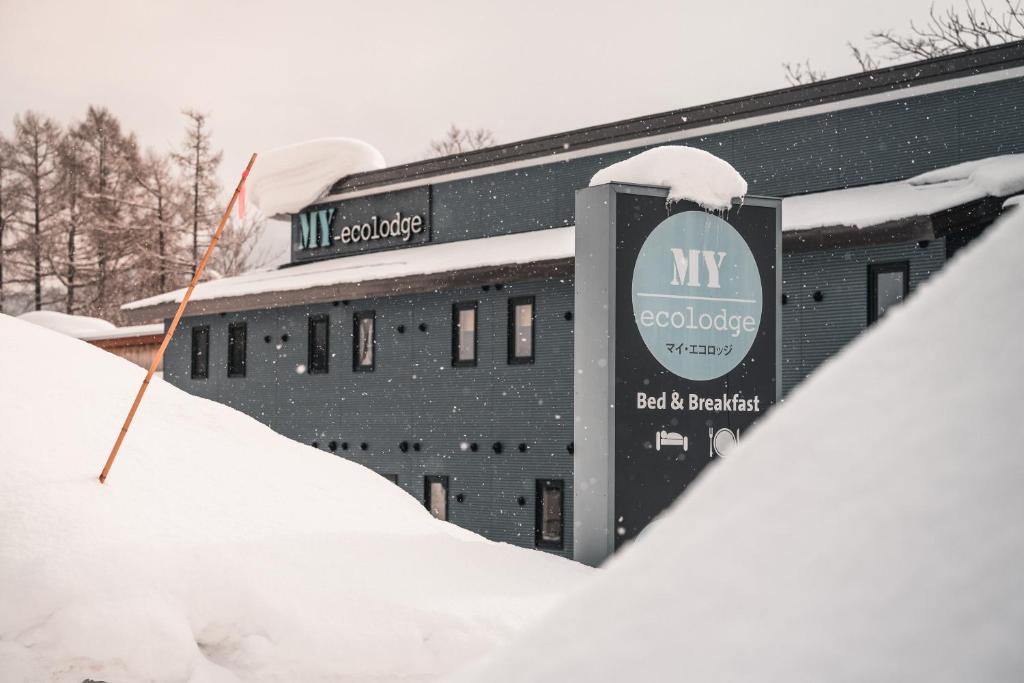 a building with a sign in the snow at My Ecolodge in Kutchan