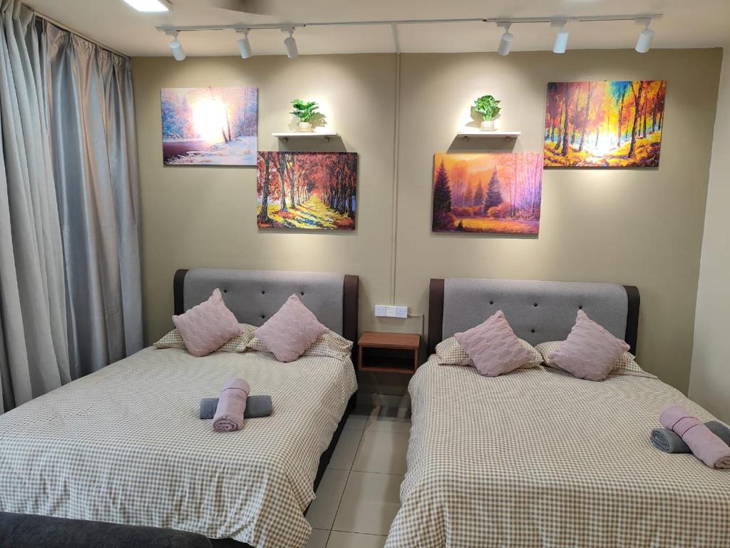 two beds in a room with paintings on the wall at Trefoil Studio Unit Near Setia City Mall 1-5 Pax in Shah Alam