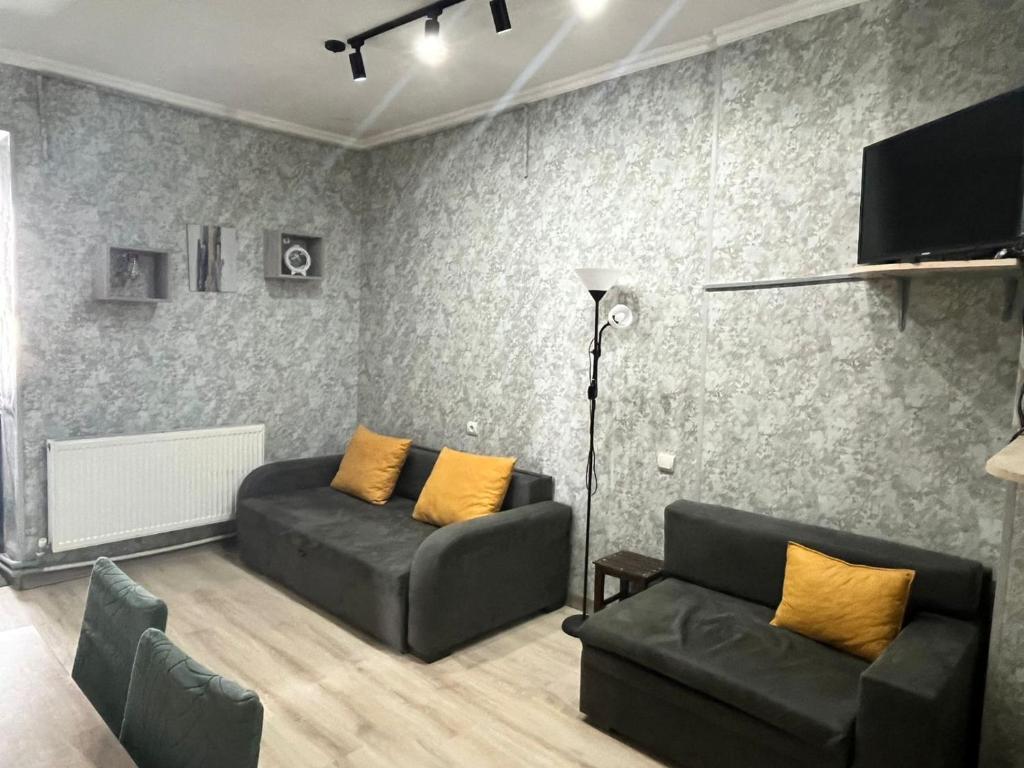a living room with two couches and a flat screen tv at Marina Apartments in Gudauri