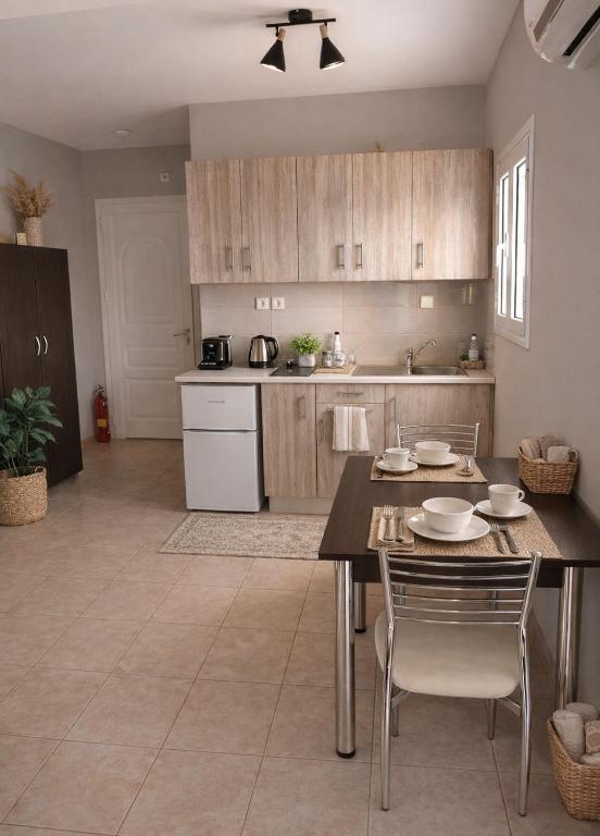 a kitchen with a table and chairs in a room at Rodanthy Studios IV in Katelios