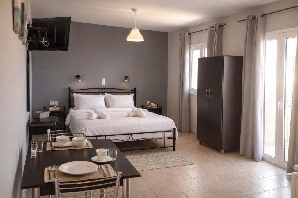 a bedroom with a bed and a table with chairs at Rodanthy III in Katelios