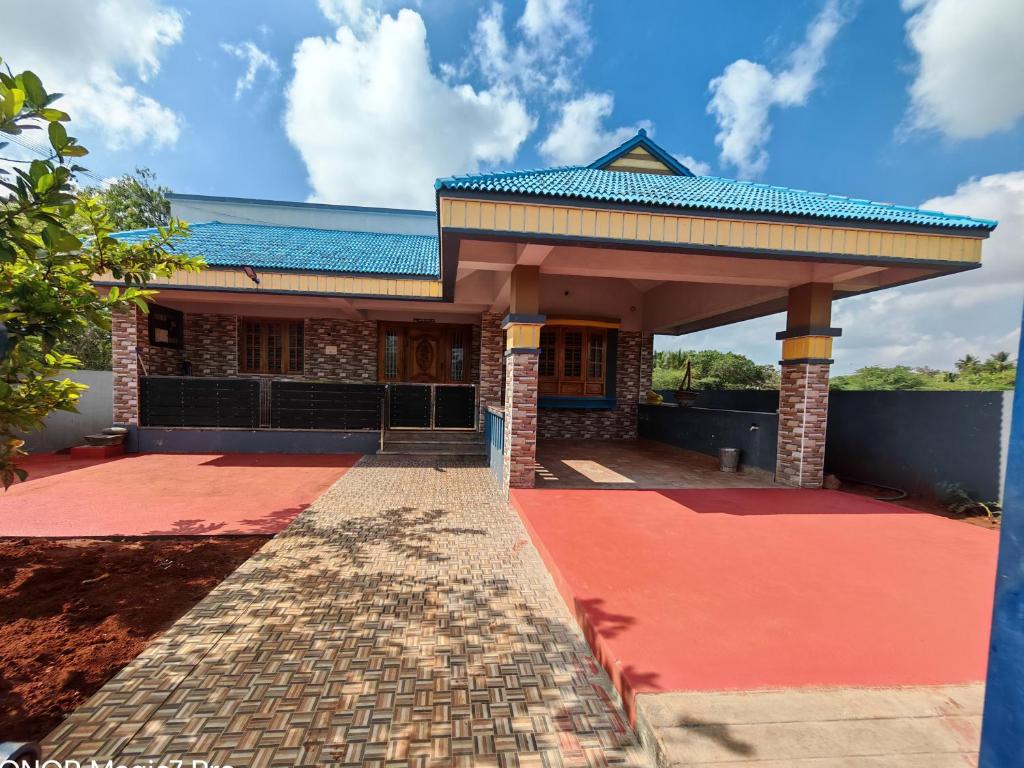 a building with a blue roof and a red floor at ARMANI Villa Nagapattinam in Sikkil