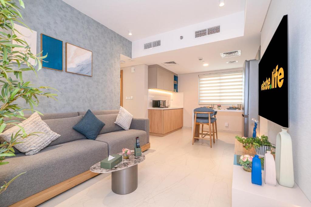 a living room with a couch and a kitchen at Tranquil Wellness Tower By Wellcube in Dubai