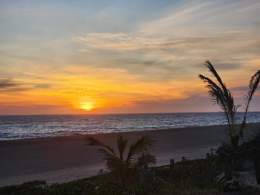 a sunset on a beach with the ocean at montegodjw in El Coco