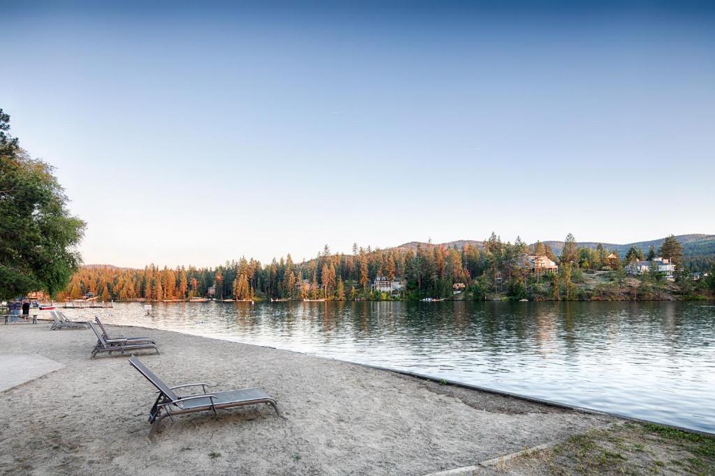 two benches sitting on the shore of a lake at Red Lion Templin's Hotel on the River in Post Falls