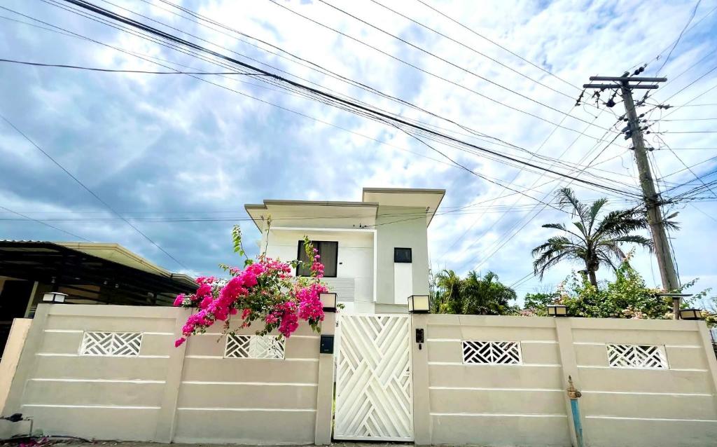 a house with a white fence and flowers on it at Casa Flores in Sampong
