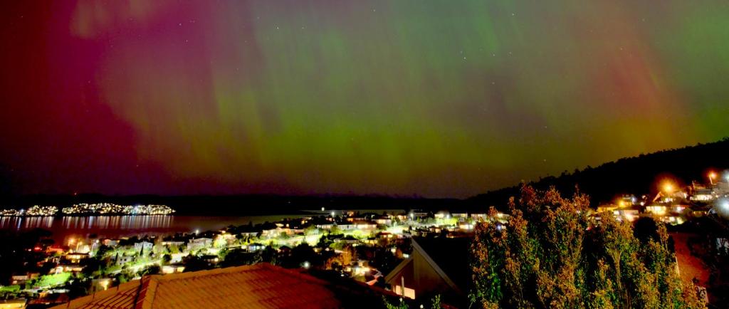 an image of a city with the aurora in the sky at Hobart Bay Sunrise House--Rare Aurora Viewing Opportunities in Hobart