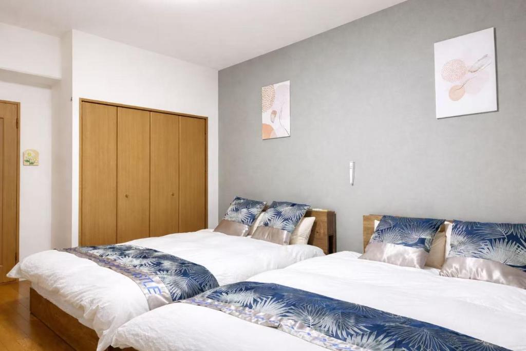 two beds sitting next to each other in a room at 星の宿大阪城 in Osaka