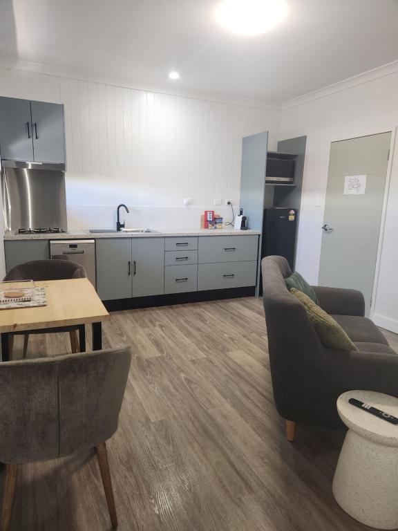 a living room with a couch and a kitchen at Wambenger Lodge in Collie