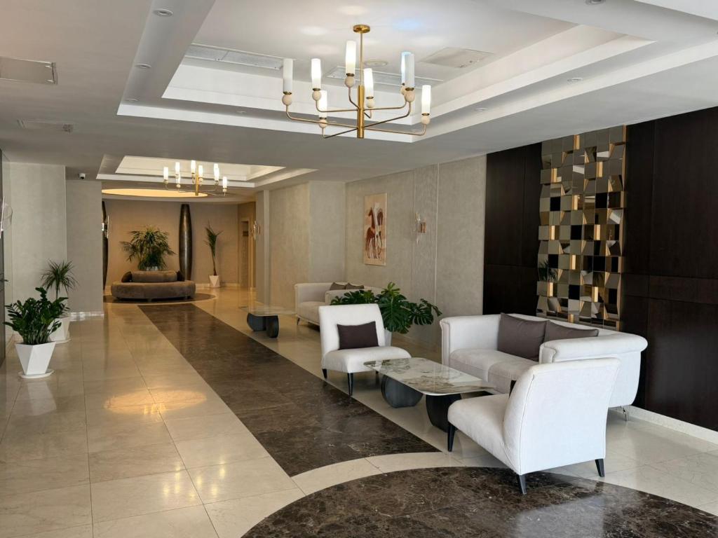a lobby with white chairs and a waiting room at Donatello Premium Almaty in Almaty