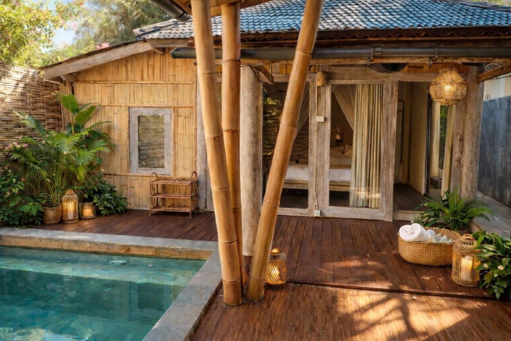 a house with a wooden deck and a swimming pool at Greengo Private POOL VILLA in Gili Meno