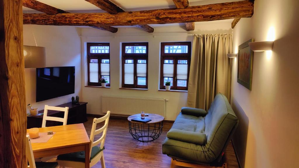 a living room with a table and a couch and a dining room at Häuslers Herberge in Stolberg