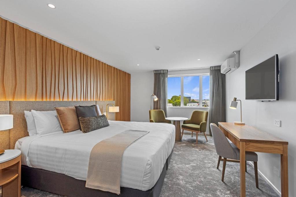 a hotel room with a large bed and a desk at Hotel Elms Christchurch, an Ascend Collection Hotel in Christchurch