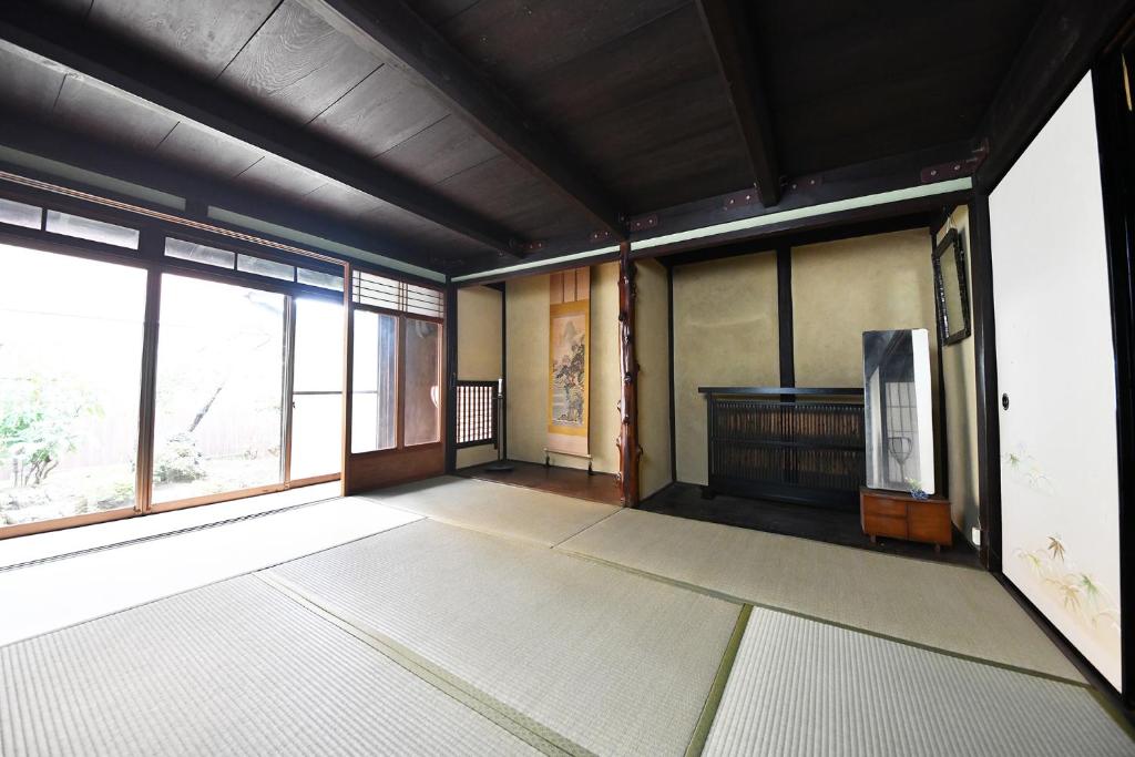 an empty room with a large window and a room with at minshuku studio enishi in Nagahama