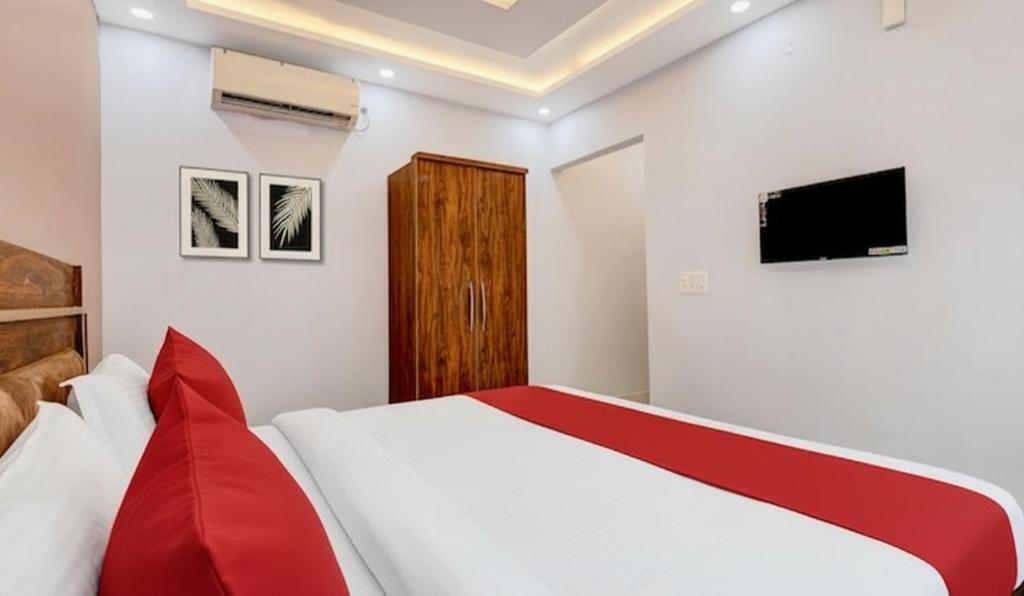 a bedroom with a bed and a tv on the wall at Super Hotel Pari Chowk Formerly The Divine KRC in Greater Noida