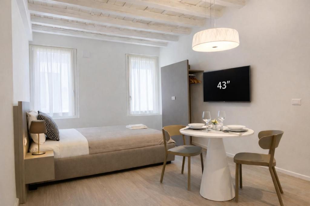 a bedroom with a bed and a table with chairs at Residenza SubitoSanto - Appartamento 6A "Galileo" in Padova