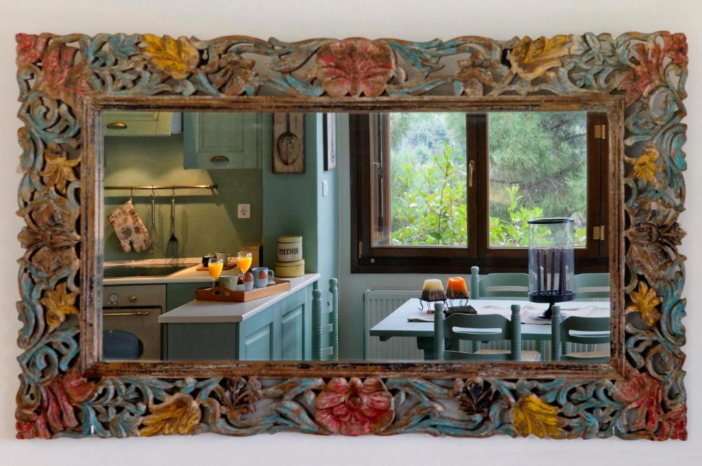un espejo que refleje una cocina con una mesa. en Centaur Suites & Maisonettes en Miléai