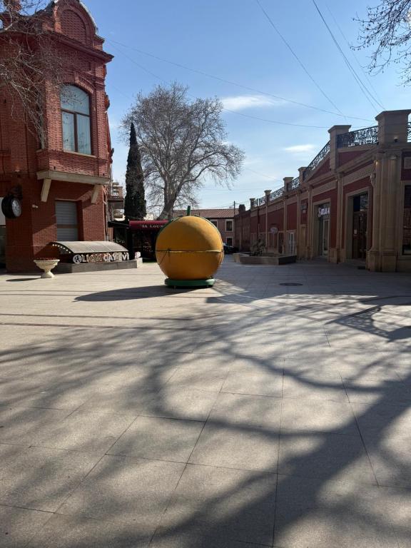 a large yellow object sitting in the middle of a courtyard at Уютная комната in Ganja