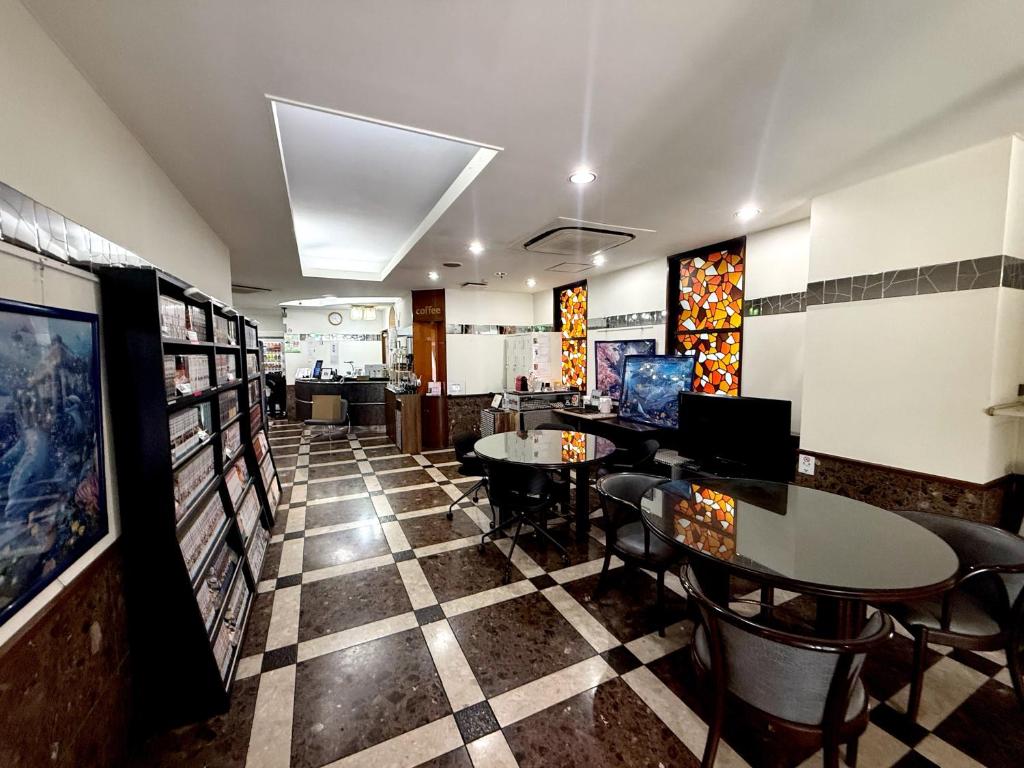 a restaurant with tables and chairs on a checkered floor at アーバンホテル森下 in Tokyo