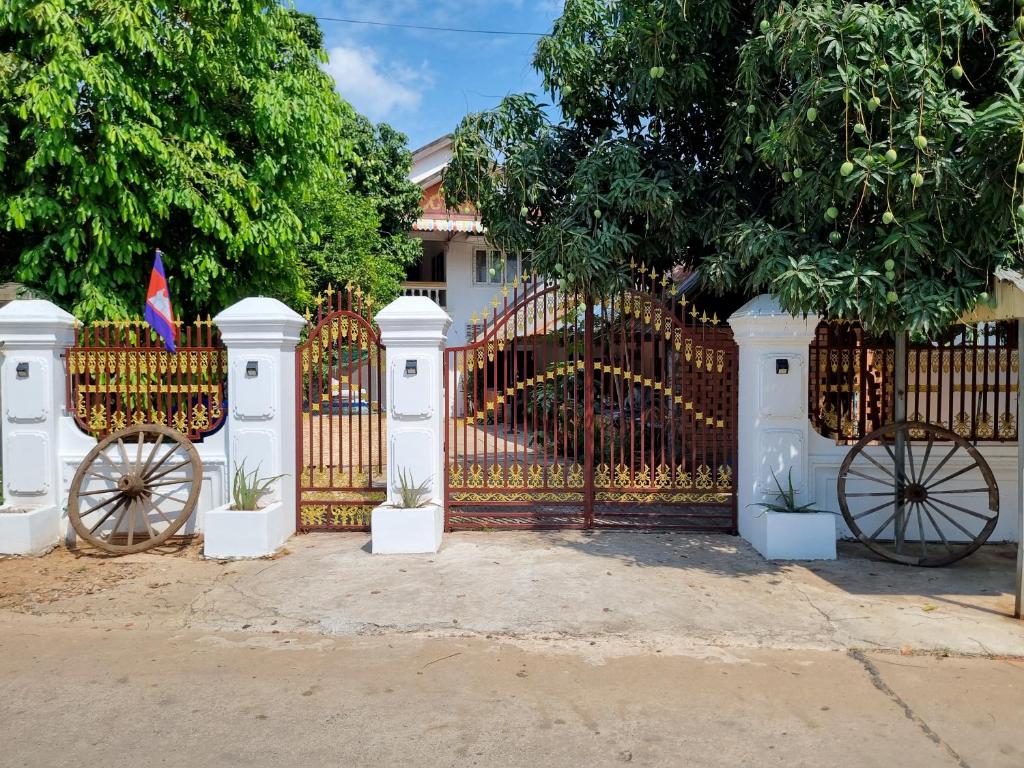 a white gate with twookedoked wheels in front of a house at Our Place Silk Island in Silk Island
