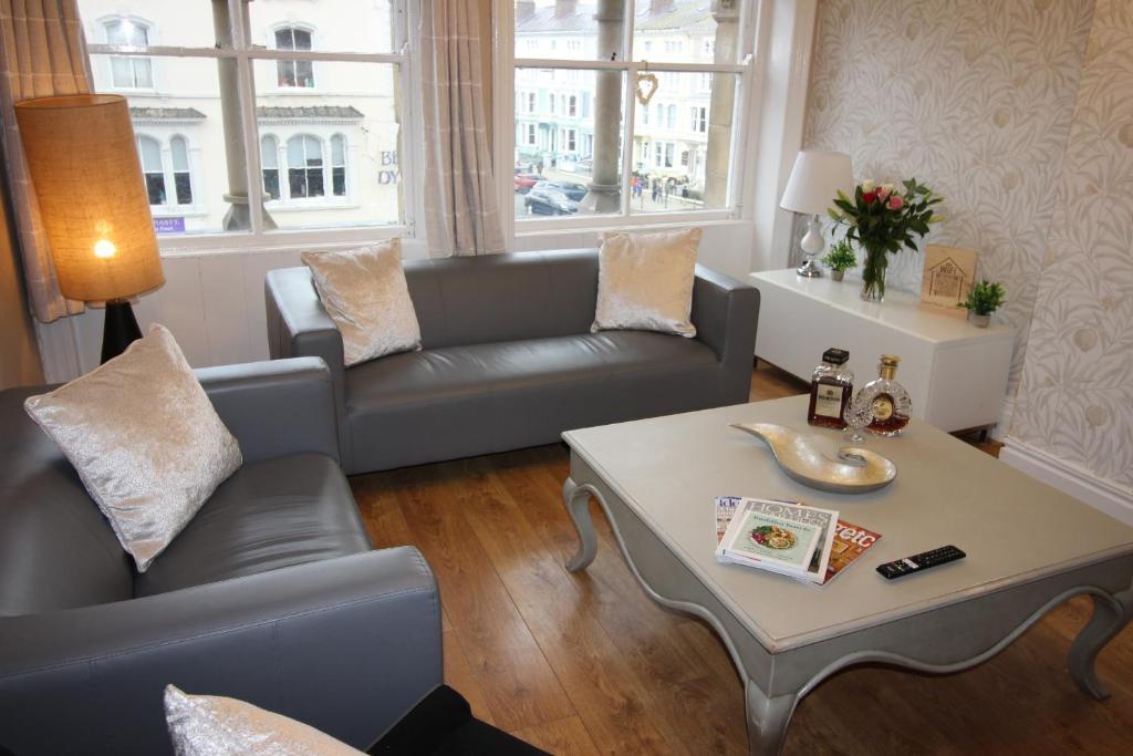 a living room with a couch and a table at Cornerhouse Apartments 3 Sleeps 7 in Llandudno