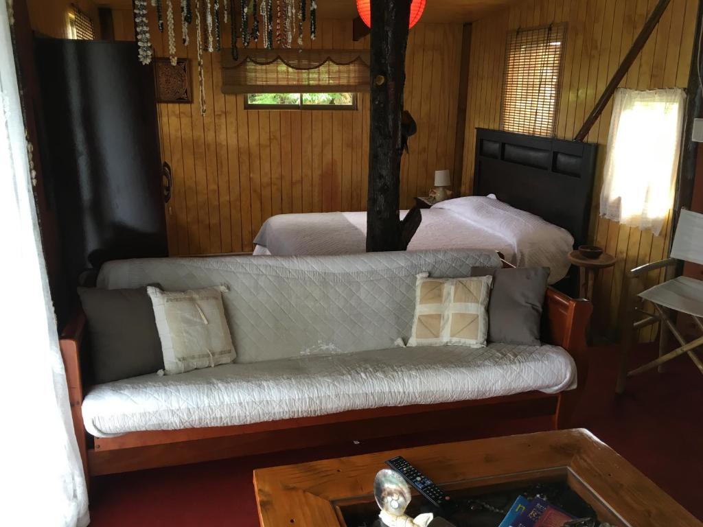 a living room with a couch and a bed at Cabañas Moai in Hanga Roa