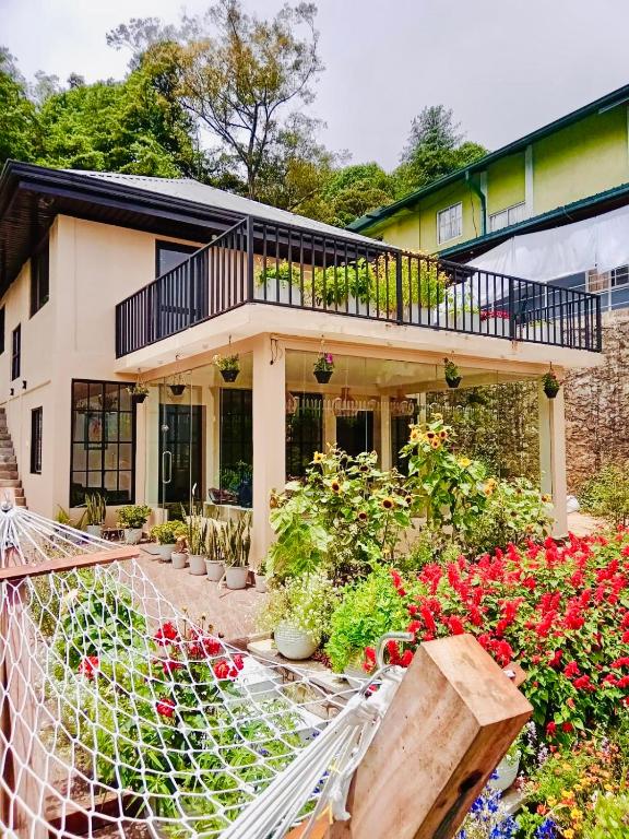 a house with a lot of flowers in front of it at Clover Cottage in Nuwara Eliya