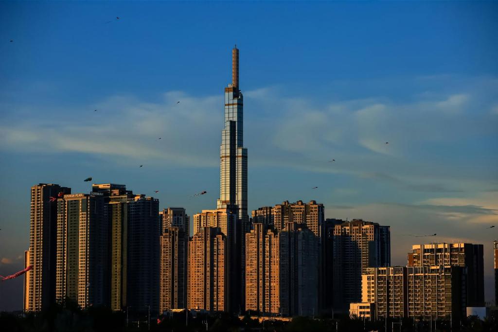 a city skyline with a tall building in the foreground at Elysian Suites In Landmark Saigon by VNS in Ho Chi Minh City