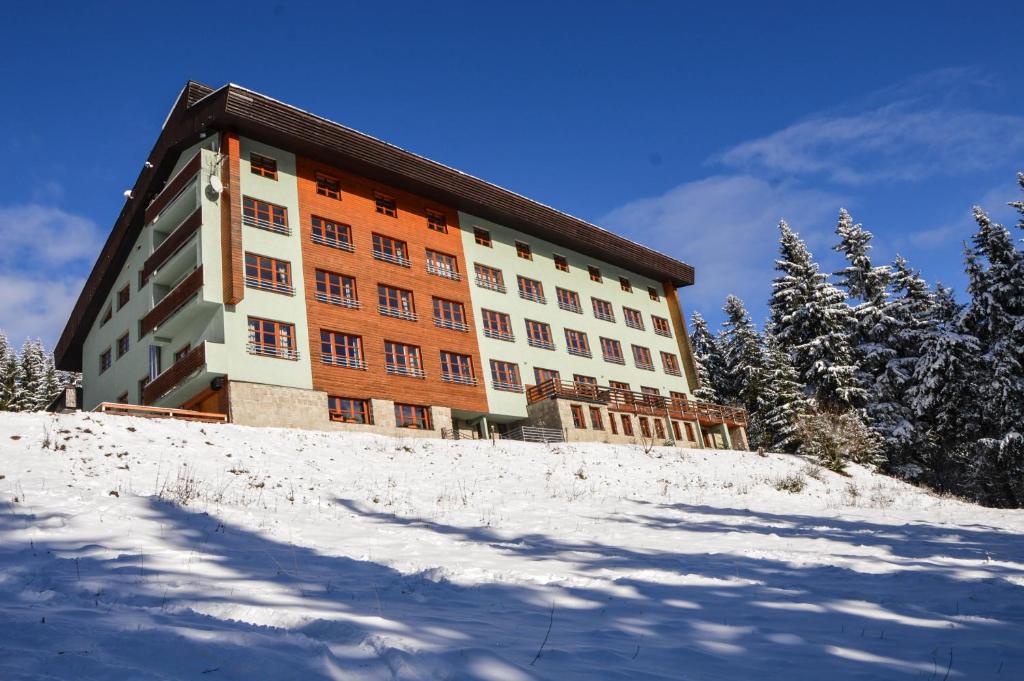 a large building on top of a snow covered hill at Cihlářka - Apartmán 309 in Pec pod Sněžkou