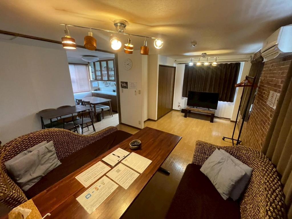 a living room with a wooden table and chairs at Hotel EL Tochigi 3 free parking in Utsunomiya