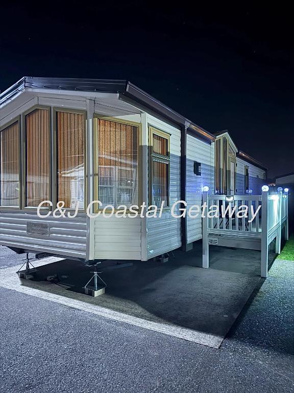 a train car is sitting on display at night at CJ Coastal Getaway #1 in Abergele