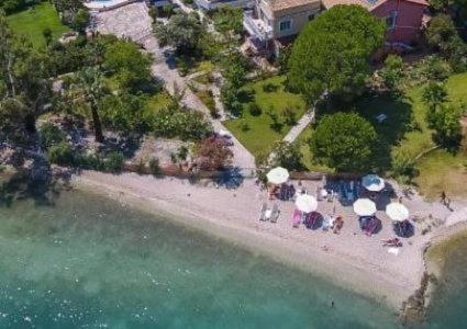 an aerial view of a beach with umbrellas and people at Palmyra Beachfront Studios in Nydri