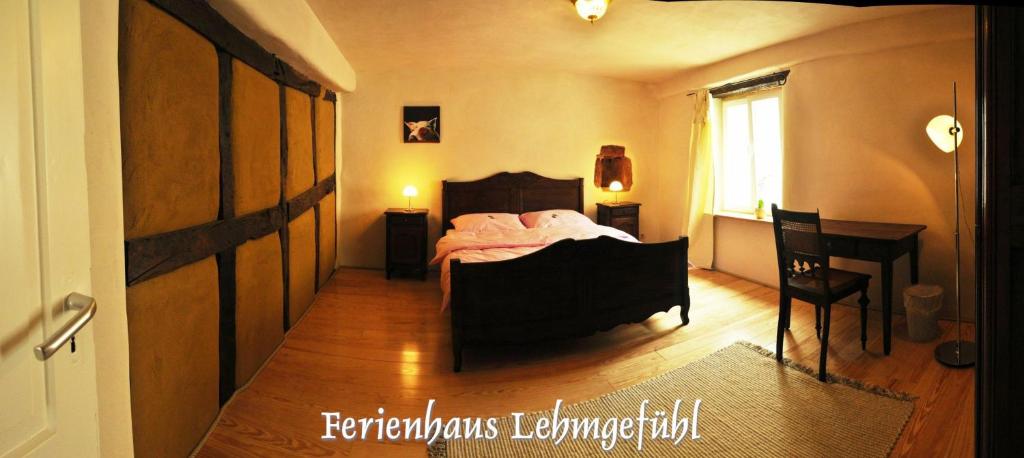 a bedroom with a bed and a desk and a window at Lehmgefühl, Design Vier, La Petite Maison in Trier