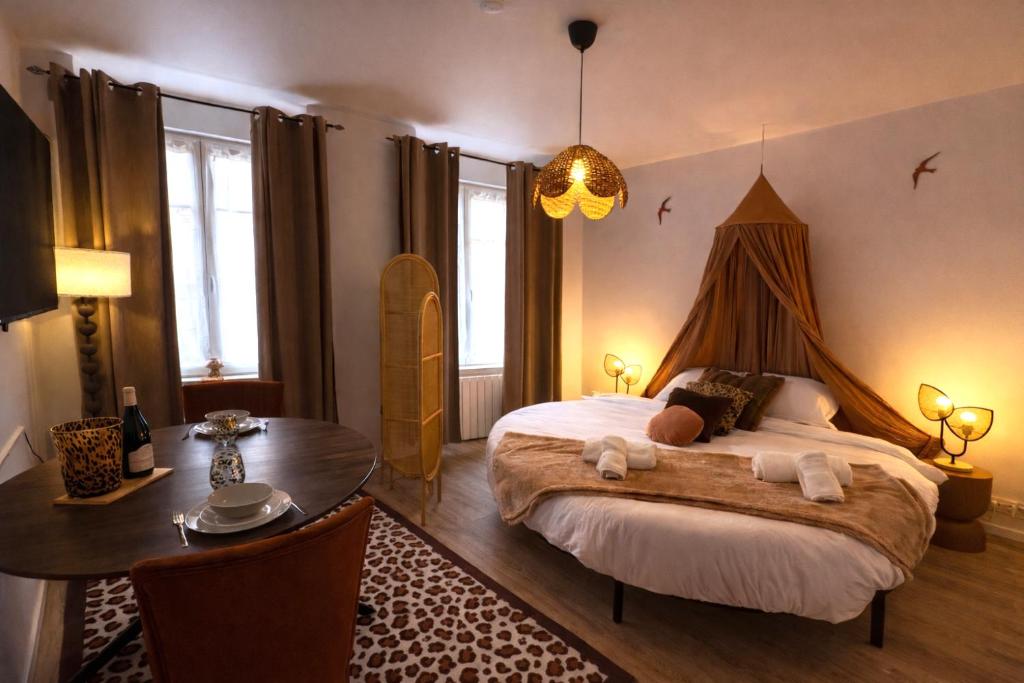 a bedroom with a large bed with a table and a desk at Little Wild - Centre Ville in Saverne