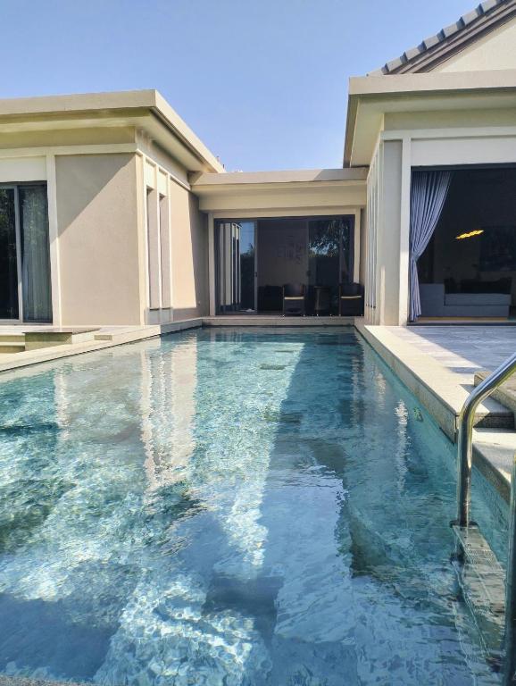 a swimming pool in front of a house at Bin Bin Coastar Villa Hồ Tràm in Ho Tram