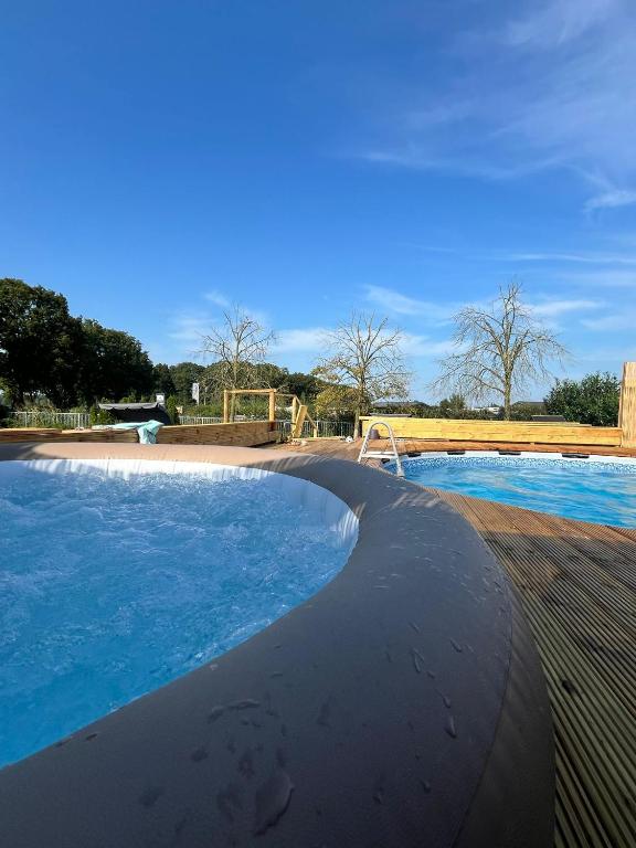 a large swimming pool with a playground in the background at Gelders genieten in Overasselt