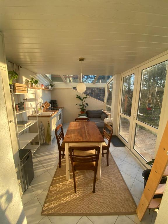a kitchen and dining room with a table and chairs at Souterrainwohnung mit Badesteg an der Paar in Friedberg