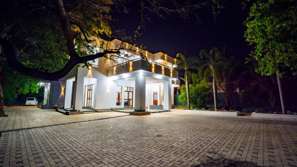 a white house with lights on it at night at OKI Nature Resort in Dambulla
