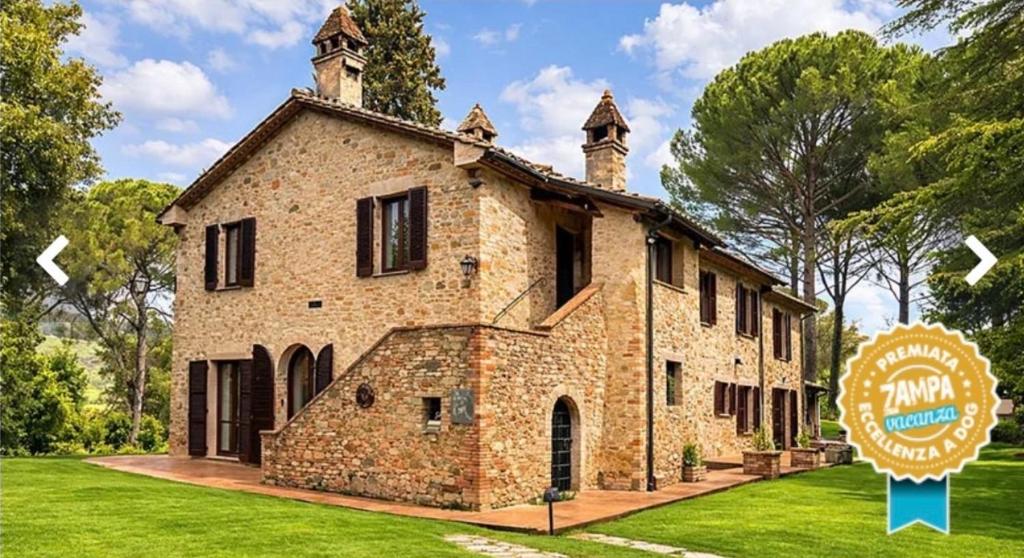 a large brick building with a sign in front of it at La locanda delle pulci in Colombella