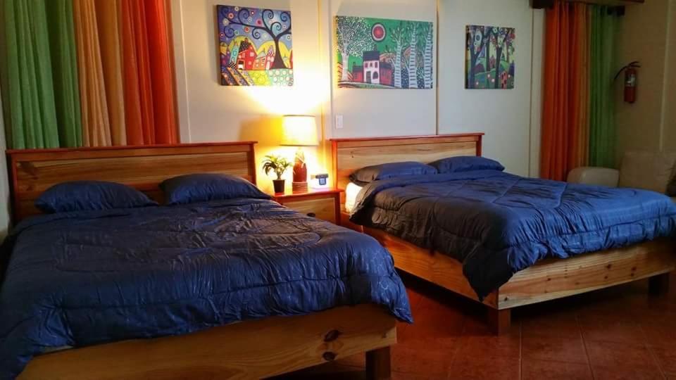 two beds sitting next to each other in a room at Family Guest House in Quebradillas
