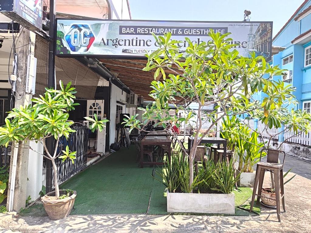 a restaurant with a table and chairs and plants at QG restaurant and guesthouse in Hua Hin
