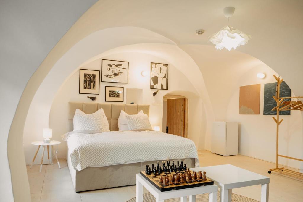 a bedroom with a bed with a chess board on it at Brána historic Boutique Apartments in Horažďovice