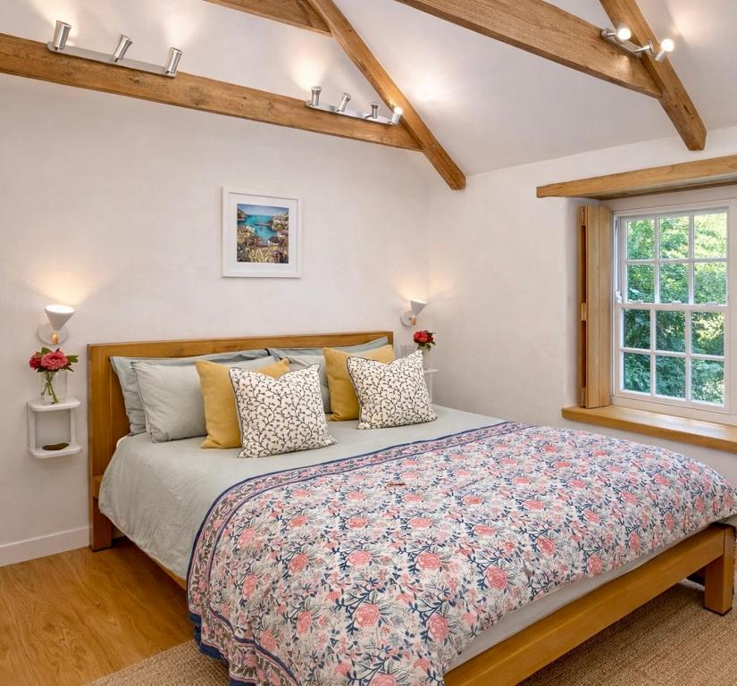 a bedroom with a large bed and a window at St Kew Escapes Nr Port Isaac in Saint Kew
